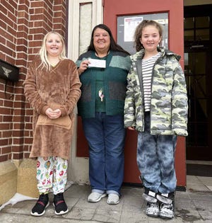 "Best Friends Lemonade" stand run by Violet Bengtson and Delta Hodgson raised money during summer events Ox Cart Days and Chalk It Up for families in need. Here, they're pictured with Care and Share social worker Tracy Smith giving a $400 donation just before Christmas.