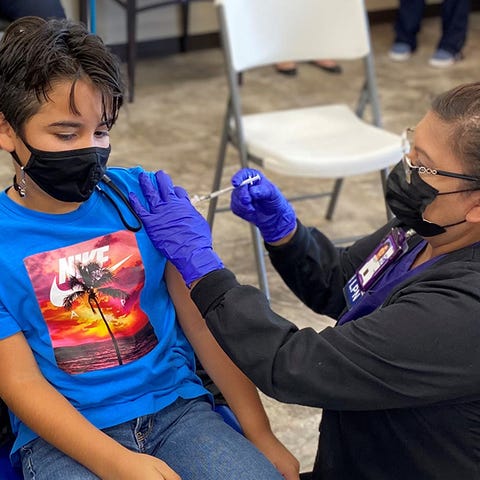 A healthcare worker administers a COVID-19 vaccine