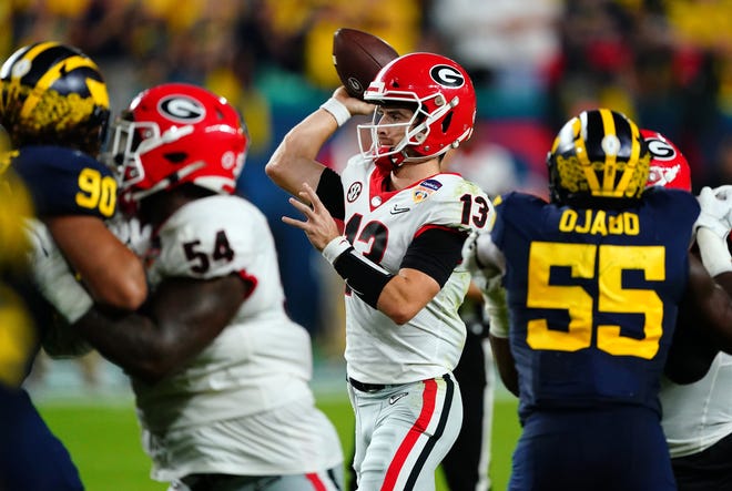Georgia quarterback Stetson Bennett (13) throws against the Michigan defense during the CFP national semifinal on Friday night in Miami Gardens, Fla.