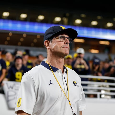Michigan coach Jim Harbaugh takes the field for wa