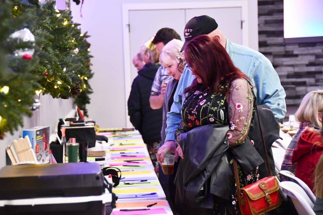 At the Blue Line Club's New Years Eve Bash fundraiser at the Eagles Club Friday guests shown here look at silent auction items. The night also included a meal, social hour, raffles, and a performance by band "Four Wheel Drive."