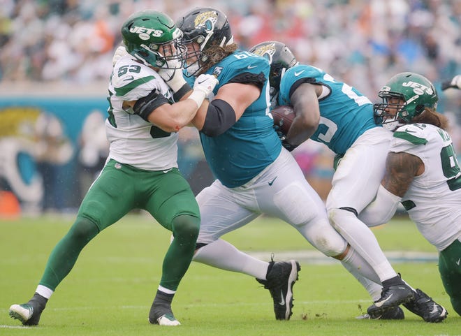 Jacksonville Jaguars offensive guard Andrew Norwell (68) battles with New York Jets linebacker Blake Cashman (53) to create running room for Jacksonville Jaguars running back Ryquell Armstead (23) during second quarter action. The Jacksonville Jaguars hosted the New York Jets at TIAA Bank Field in Jacksonville, Florida, October 27, 2019. The Jaguars went into the half with a 19 to 7 lead. [Bob Self/Florida Times-Union]