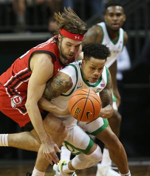 Oregon's Jacob Young, right, forces a turnover against Utah's Rollie Worster during the second half Saturday.