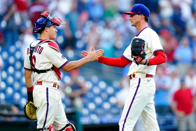 Phillies catcher J.T. Realmuto, left, and relief pitcher Connor Brogdon shake hands after a win over the Nationals.