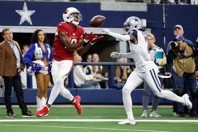 Arizona Cardinals wide receiver A.J. Green (18) catches a pass for a first down as Dallas Cowboys cornerback Trevon Diggs (7) defends during the first half of an NFL football game Sunday, Jan. 2, 2022, in Arlington, Texas.