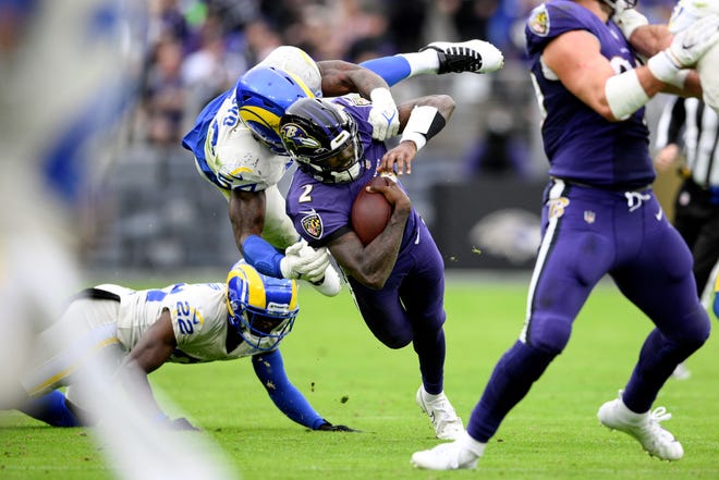 Baltimore Ravens quarterback Tyler Huntley, center, is tackled by Los Angeles Rams outside linebacker Leonard Floyd, top, while scrambling for yardage during the second half of an NFL football game, Sunday, Jan. 2, 2022, in Baltimore. (AP Photo/Nick Wass)