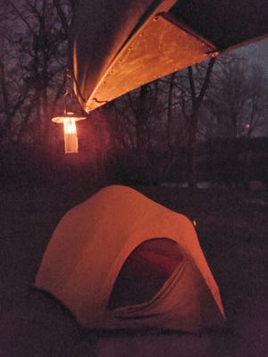 A candle lantern, which I've owned for at least 25 years, casts a soft glow on my canoe and tent during a winter river trip last January.
