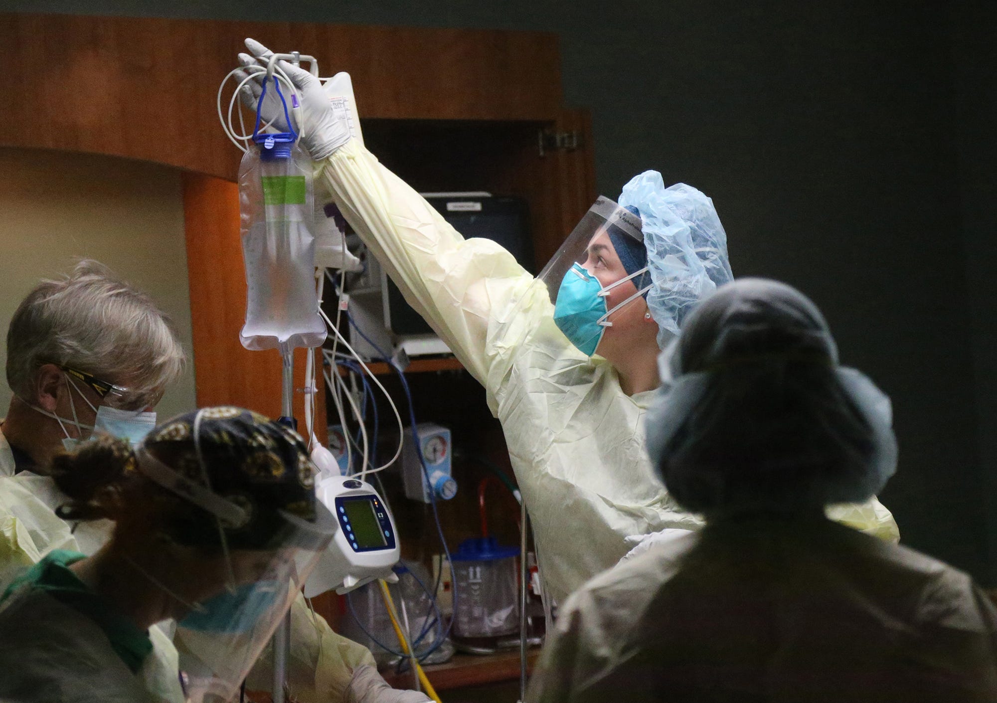 Becky Roy, a registered nurse, clears the area surrounding a COVID-19 patient at Wentworth-Douglass Hospital.