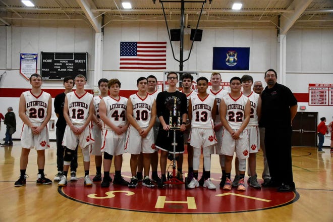The Litchfield Terrier boys basketball team stands with their Christmas Tournament Trophy after defeating Tekonsha in the finals.