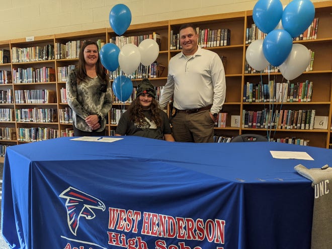 With his parents (Scott and Miranda) as witnesses, West Henderson High football standout Tye Galloway signs to play football at Brevard College on Dec. 16 at West's media center.