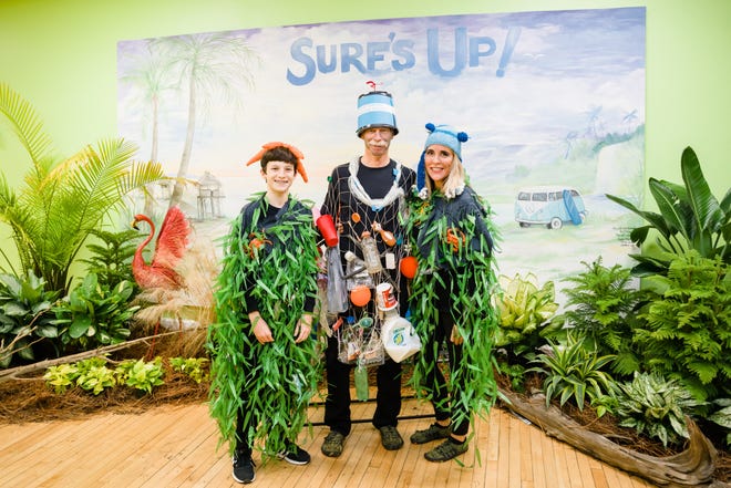 Pete Clark, left, and Penny Simon, right, dress as kelp forests, complete with small ocean creatures in the kelp, at the Children’s Museum Gala, representing a clean and pristine ocean environment. Chris Clark, center, Pete’s Dad, represents the Great Pacific Garbage Pile, a vortex in the middle of the Pacific Ocean where tons of plastic waste end up. Chris gathered plastic waste for his costume from a lake near his Knoxville home. The Museum invited guests to dress in ocean and beach-theme costumes, and the three made their costumes for the event.