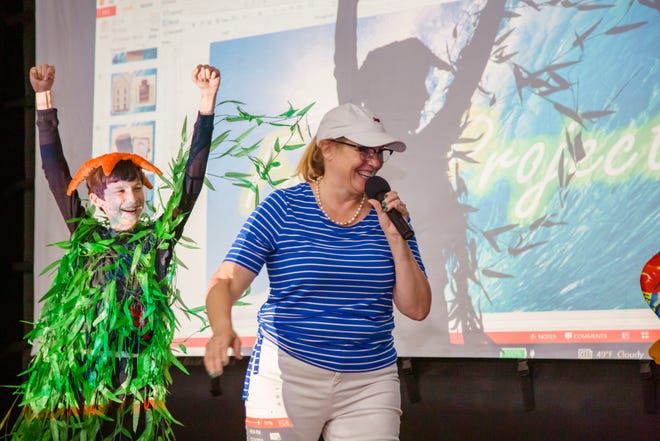 Pete Clark, in an ocean kelp forest costume with a starfish hat, reacts with excitement as Children’s Museum Gala emcee Leslie England announces that the audience chose him for first place in the costume contest.