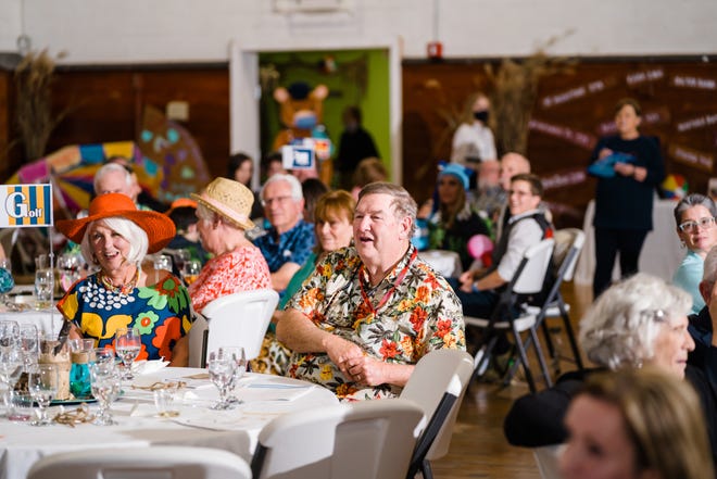 Sandy and Tom Tuck, retired president of TNBank, attend the Children’s Museum Gala in their beach attire, a bright summer dress and hat for Sandy and Hawaiian shirt for Tom.