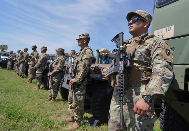 Members of the Texas Army National Guard stand by as Texas Gov. Greg Abbott and 10 other governors hold a press conference at Anzalduas Park on Oct. 6, 2021, in Mission.
