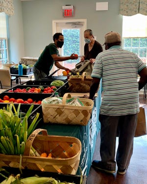 Forsyth Farmer's Market Programs Director Mark Bowen assists Farm Truck 912 customers with product selection and training.