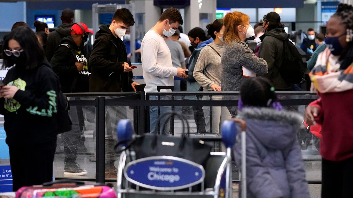 Travelers line up at Chicago's O'Hare International Airport on Dec. 30, 2021. Thousands of U.S. flights were canceled or delayed each day of the holiday travel season.