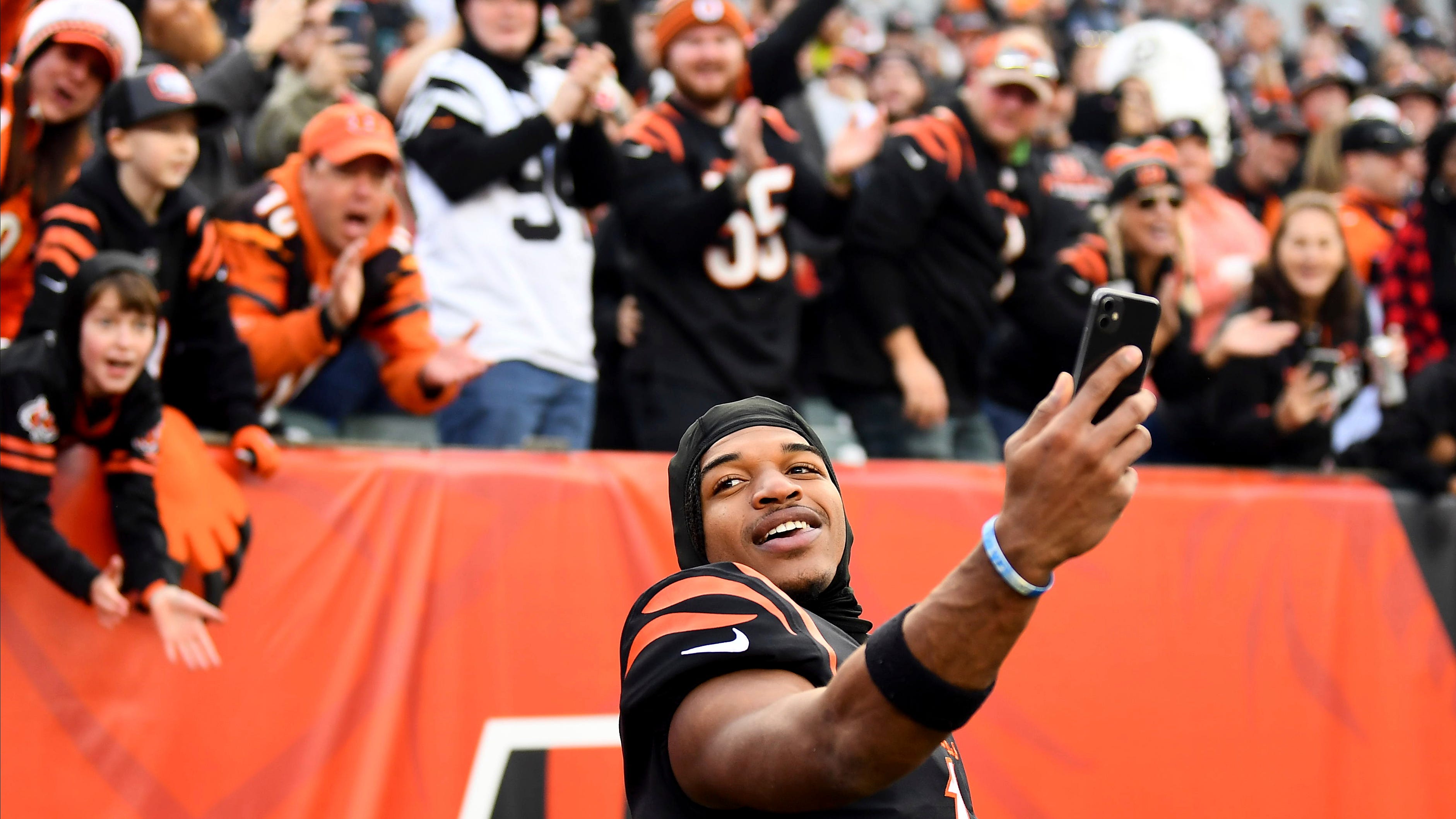 Cincinnati Bengals wide receiver Ja'Marr Chase (1) takes a video with fans after a 41-21 win over the Baltimore Ravens after an NFL football game, Sunday, Dec. 26, 2021, in Cincinnati.
