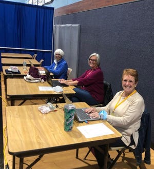 Jackie Roberson (left), Ann Haley, and Becky Williamson sit behind the scene of the Big Registration as they prepare to enter membership data for the Destin Snowbird Club last Monday, Jan. 3.