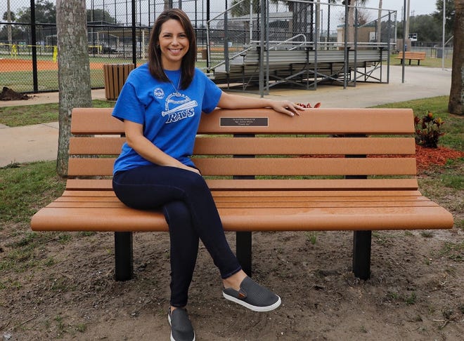 Carlyn White sits on the bench she worked to have installed in memory of her husband, Justin White, who died from COVID-19 complications in August. The bench is located behind the backstop of field No. 1 in Port Orange's City Center Sports Complex where Justin coached one of his sons in Little League.