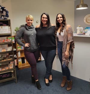 From left, Jessica Leahey, who runs Blue Moon Massage, Tricia Tappen, owner of Mew Moon, and Danielle Botelho, owner of Leading Performance Chiropractic, stand inside the New Moon gift shop at its grand opening in November.