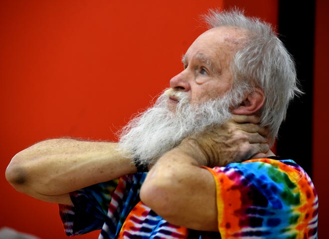 Thomas Bresnay, 72, works on stretching his neck during the Holly Yoga fitness class at the Monroe Family YMCA.