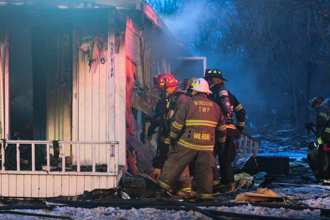 First responders work at the scene of a fire at Windmill Park in Holt off of Eifert Road, Tuesday, Jan. 4, 2022.