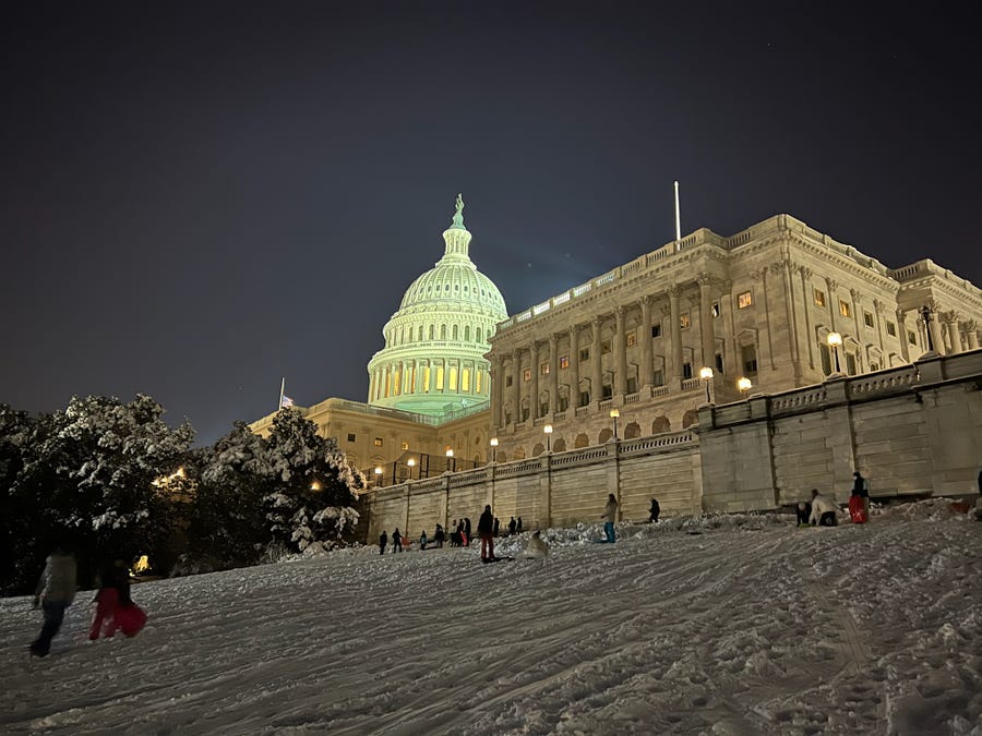 Washingtonians enjoy sledding under the glow of the U.S. Capitol on Jan. 3, 2022.
