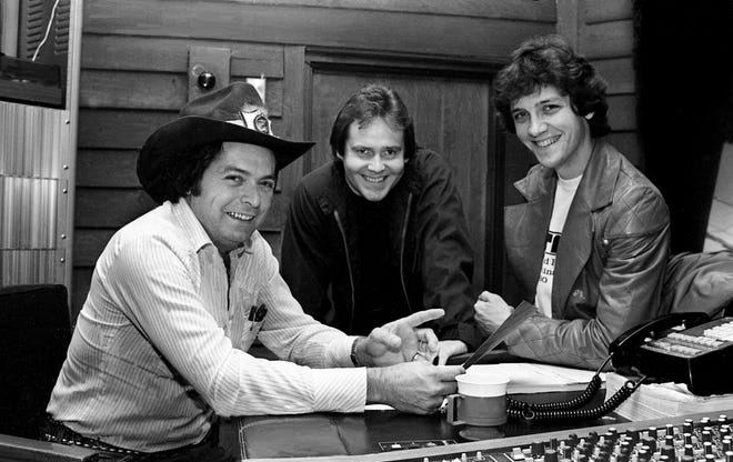 Dainininkas Mickey Gilley, kairėje, dalijasi akimirka su dainų autoriais Stewartu Harrisu ir Keithu Stegallu, savo naujausio hito bendraautoriais. "Vienišos naktys," „Music Row“ studijoje sausio mėn.  1982 m. 21 d.