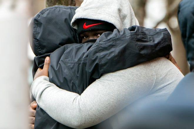 Isaiah Brown, who identified himself as a family member of all the victims, is hugged following a fatal fire on the 800 block of N. 23rd Street in Philadelphia, Pa. on Wednesday, Jan. 5, 2022.