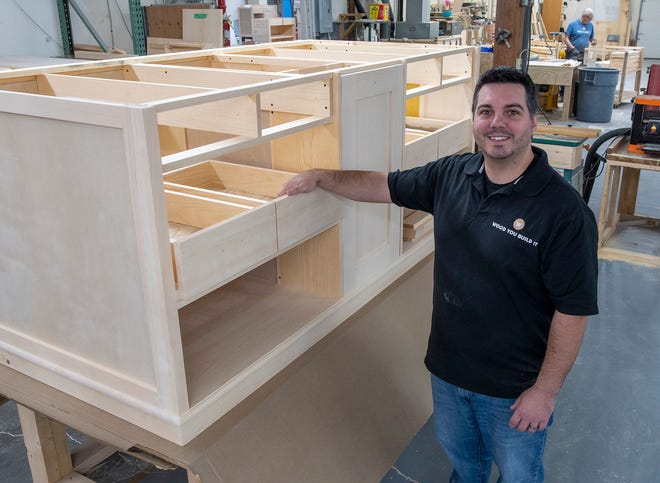 Wood You Build It owner Justin Robichaud shows off a kitchen island ready for paint in his Gardner woodworking shop Thursday.