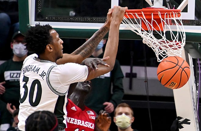 Penyerang Michigan State Spartan Marcus Pingham Jr. (30) mengalahkan penyerang Nebraska Cornhuskers Lot Mayon (11) pada babak pertama di Jack Breslin Student Events Center, Rabu. Januari 5, 2022.