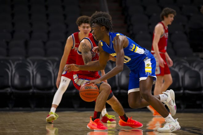 Kamari Lands from Hillcrest Prep runs with the ball as Rickey Bradley from Phoenix Prep attemps to block him during a basketball game at the Footprint Center in Phoenix on Jan. 5, 2022.
