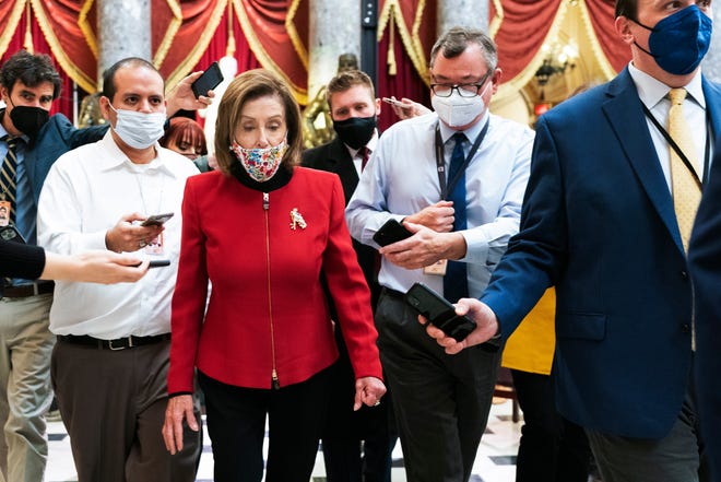 House Speaker Nancy Pelosi of Calif., is surrounded by reporters in the National Statuary Hall at the Capitol as she walks back to her office, Thursday, Jan. 6, 2022 in Washington.