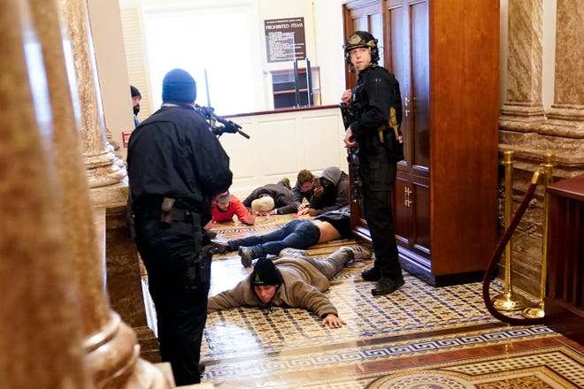 U.S. Capitol Police officers hold rioters at gun point on Jan. 6, 2021.