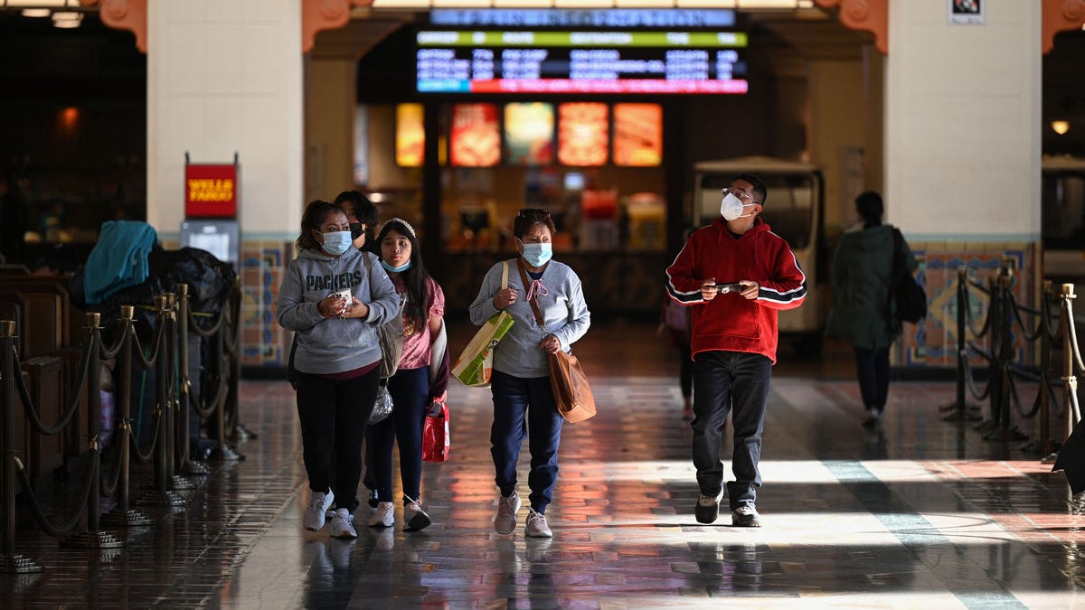 A family wearing face masks walks through Union Station in Los Angeles, California, Jan. 5, 2022.   With the Omicron variant driving a surge of Covid-19 cases, California announced Jan. 5, 2022 that a statewide indoor mask mandate, due to expire on Jan. 15, 2022, will be extended until at least Feb. 15, 2022.