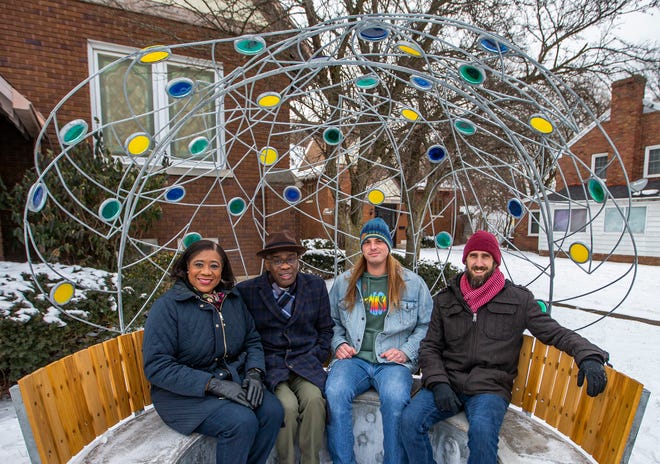 (Left to right) The Rev. Tina Patton and her husband, The Rev. Michael Patton, sit with Gage Ratkay, an IUSB student, and Brian Hutsebout, an IUSB professor, on a new bench, created by IUSB'S Department of Sustainability, which has been installed outside Kingdom Life Christian Cathedral in South Bend.