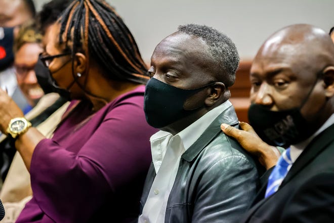 Ahmaud Arbery's father, Marcus, center, sits next to civil rights attorney Ben Crump, right, during the sentencing hearing for the three men convicted of murdering his son last year.