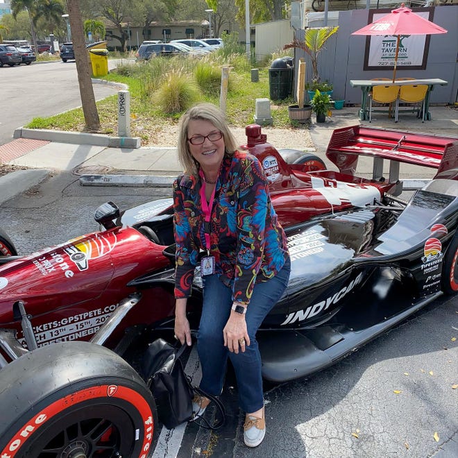 Terri Hall is pictured with an Indy race car that was part of a public relations project done by her company, Doubletake Marketing.