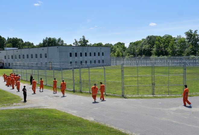 Inmates walk outdoors at the Worcester County Jail and House of Correction.