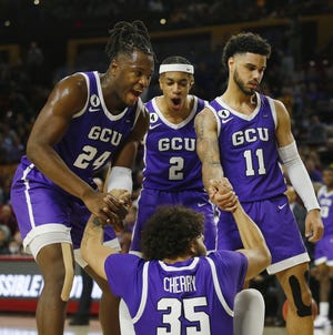 Dec 9, 2021; Tempe, AZ, United States; GCU's Holland Woods (11), Yvan Ouedraogo (24) and Chance McMillian (2) celebrate with Taeshon Cherry (35) after Cherry drew a charge against ASU during a game at Desert Financial Arena. Mandatory Credit: Patrick Breen-Arizona Republic
