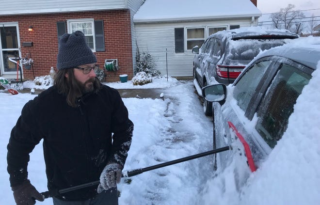 Mike Schwartzburt clears off his car after a second winter storm this week dropped snow in Delaware on Friday, Jan. 7, 2022.