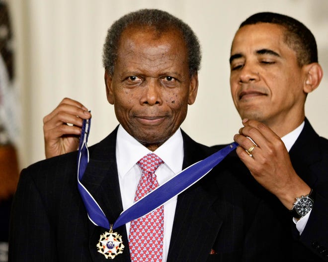 Former President Barack Obama presents the 2009 Presidential Medal of Freedom to Sidney Poitier during ceremonies in the East Room at the White House in Washington.