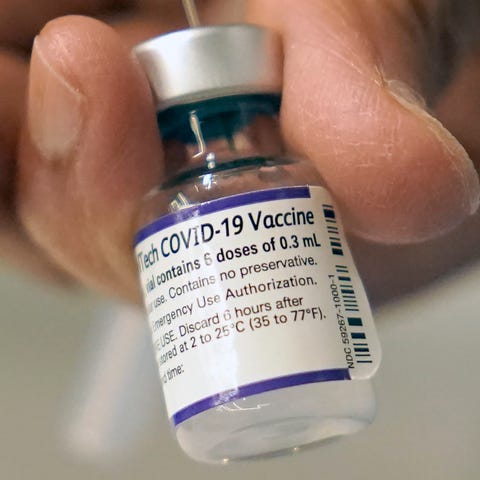 A doctor loads a dose of Pfizer COVID-19 vaccine i