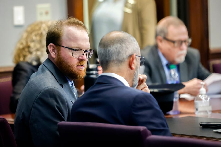 Travis McMichael, left, speaks with his attorney, Jason Sheffield, center, during the sentencing hearing for the murder of Ahmaud Arbery. Travis, his father, Gregory, right, and William "Roddie" Bryan were sentenced to life in prison Jan. 7 at the Glynn County Courthouse in Brunswick, Ga.