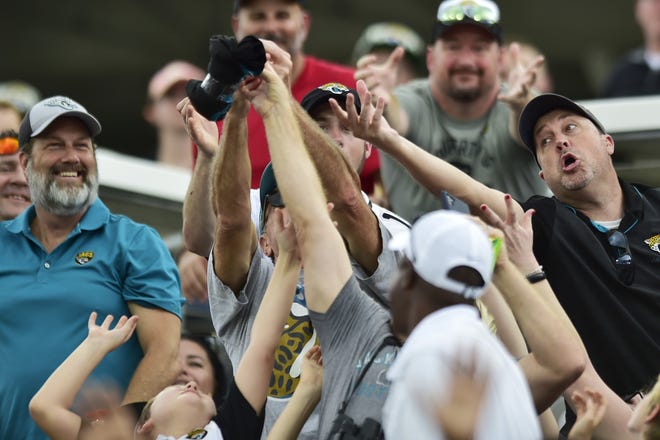 Fans try to catch a t-shirt shot from a cannon during the second quarter in a December game against the Texans.