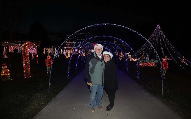 Dan and Rose Rambacher in front of their home Friday in Sagamore Hills. The couple raised over $37,000 for St. Jude's Hospital in donations from admirers of their Christmas light display this season.