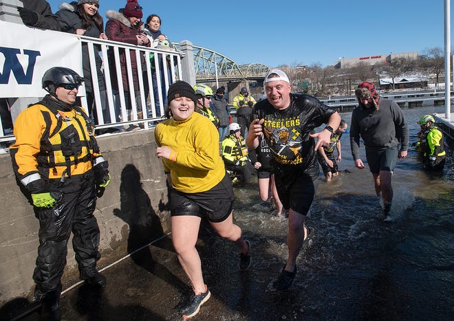 Members of the River Rats run out of the Beaver River after participating in the Polar Plunge Saturday morning in Bridgewater. Thirty groups ran into the 30-degree water to benefit Special Olympics of Pennsylvania.