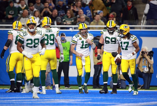 Green Bay Packers quarterback Aaron Rodgers celebrates with David Bakhtiari (69) and Davante Adams (17) after throwing a touchdown pass to Allen Lazard during the first quarter against the Detroit Lions at Ford Field on Sunday.