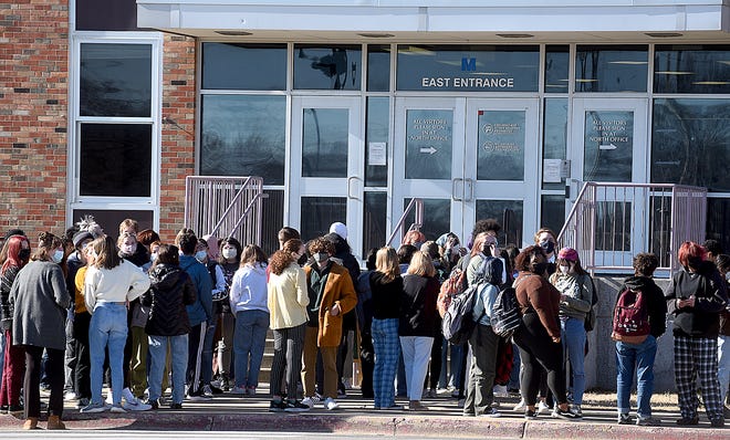 About 120 students from Hickman High School in Columbia, Missouri, stand outside the school at noon Monday during a planned walkout to protest the school board’s decision to rescind the mask mandate for Columbia Public Schools.