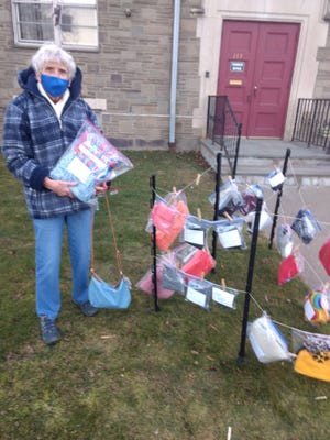 Diane Runion hangs a scarf outside her church: Main Street Baptist Church on Binghamton’s West Side. Church members donate scarves, hats and mittens to anyone who needs them.